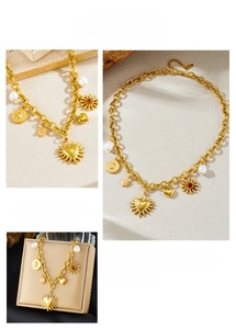 Detail of vintage gold thick chain necklace with pearl, sun and heart charms