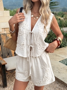 Detail of bohemian cream vest and shorts set with exquisite embroidery on poolside