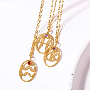Detail of gold constellation pendants with turquoise accents on dainty layered chains