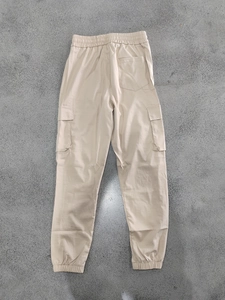 Detail of elastic waistband and cargo pockets on beige outdoor jogger pants