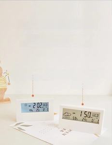 Macro shot of minimalist digital alarm clock display with temperature and humidity icons