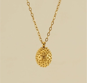 Macro shot of the 18k gold plated durian fruit pendant necklace with grainy texture