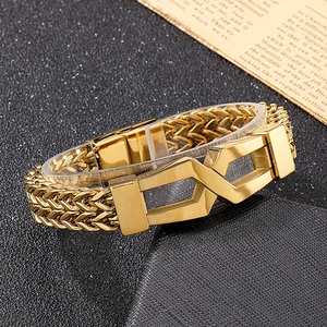 Close-up of golden braided titanium steel bracelet with geometric buckle on dark background