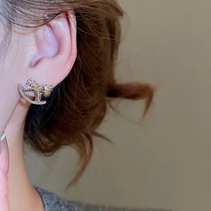 Boucles d'oreilles cheval à bascule dorées avec texture martelée et zircone