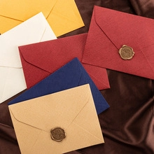 Detailed shot of multi-colored textured envelopes with vintage wax seals on dark silk