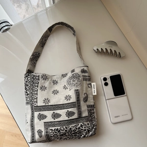 Detail of vintage bandana pattern canvas bag with simple wish label on white background