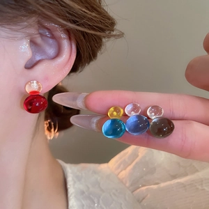 Macro shot of candy-colored resin double ball earrings in vibrant translucent finishes