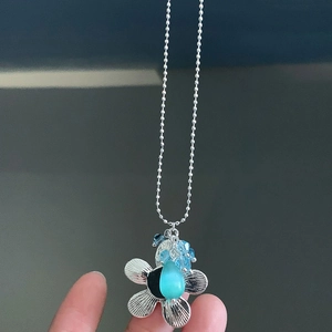 Silberne Perlenkette mit blauem Blumenanhänger und Katzenaugenstein-Dekoration