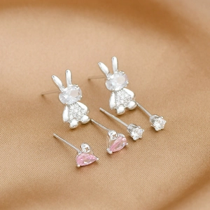 Macro shot of S925 silver stud earring set with rabbit, round, and heart rhinestones