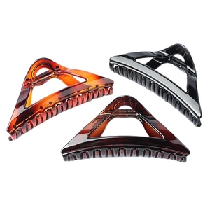 Three elegant triangle hair claws in black, tortoiseshell, and amber on white background