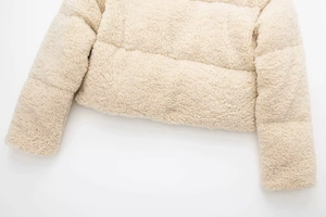 Détail de la veste matelassée en polaire crème montrant la texture douce et la manche