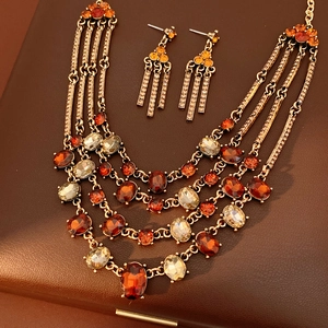 Detail of vintage bronze multi-layered necklace and earrings with amber gemstones