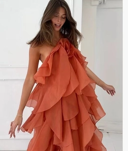 Detail of orange tiered ruffle halter dress with light organza layered floral design