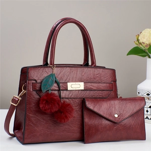 Detailansicht des weinroten PU-Leder Taschen-Sets mit Kirsch-Anhänger und passender Clutch