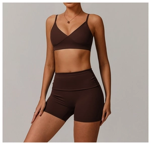 Detailed view of chocolate brown recycled fabric on the sporty V-neck bra and yoga shorts