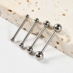 Polished G23 titanium tongue and nipple rings set in four varying sizes on stone surface