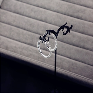 Detailed close-up of oversized silver hoop earrings with sparkling rhinestones on display