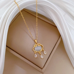 Detail of Ruyi lock pendant with opal stone and zircon drops on golden chain