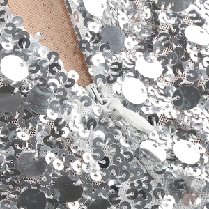 Macro shot of silver sequins on mesh fabric with an invisible zipper on a long dress