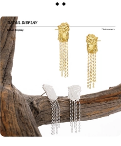 Macro view of geometric square fringe earrings with textured silver and long metal tassels