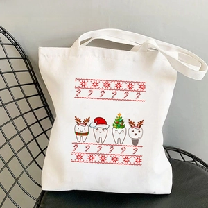 Canvas tote bag with cute Christmas teeth print on a black grid chair in close-up detail