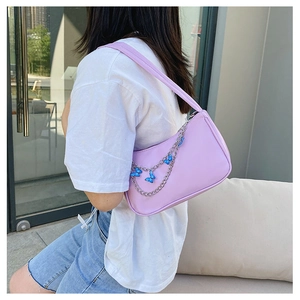 Chic lavender underarm bag with decorative silver butterfly chain on female model