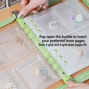 Detail of green binder jewelry organizer with loose-leaf rings and clear PVC pockets