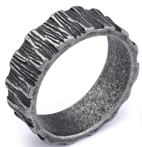 Macro detail of silver textured ring with rustic tree bark pattern on smooth inner band