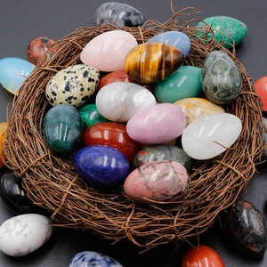 Polished natural crystal 30mm egg shaped gemstones in a woven nest with smooth textures