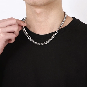 Close-up of a thick silver titanium steel curb chain necklace on a male model neck