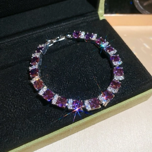 Macro shot of French style wave bracelet featuring square purple zircons on black velvet
