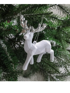 Close-up of a white flocked reindeer ornament with silver glitter antlers on a tree