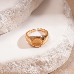 Anello con sigillo dorato lucido con gambo aperto regolabile su roccia bianca