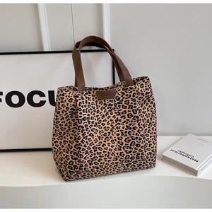 Gros plan du sac cabas en toile imprimé léopard avec anses marron et étiquette en cuir