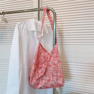 Macro detail of red paisley cotton tote bag showing the soft fabric texture and wide strap