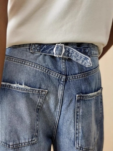 Loose wide-leg washed denim jeans with adjustable metal waist buckles and distressed details