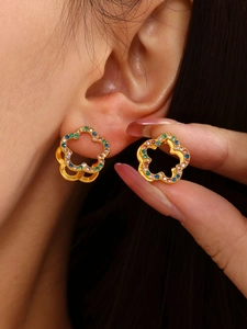 Close-up of gold flower earrings with colorful zircon stones on model's ear
