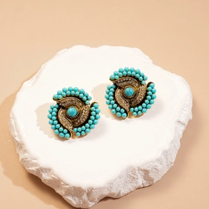Detail of vintage flower earrings with turquoise beads and rhinestones on gold base