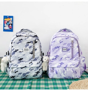 Detail view of durable camouflage school backpacks with cute white bear accessories