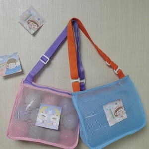Detail of blue and pink mesh beach bags with colorful straps and cartoon charms
