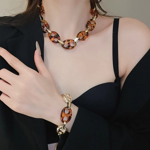 Dettaglio del set collana e bracciale in resina leopardata ambrata e metallo oro