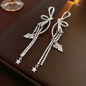 Boucles d'oreilles pendantes argentées avec nœud, étoile et strass blancs scintillants