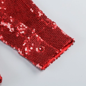 Close-up of red sequined cuff with matching decorative button on a fashionable top