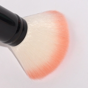 Dual-ended makeup brush with fluffy orange gradient bristles and sleek black handle