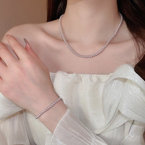 Close-up of elegant lavender pearl necklace and bracelet set on model with a warm glow