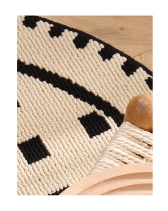 Close-up of beige and black geometric woven carpet with solid wood rope chair