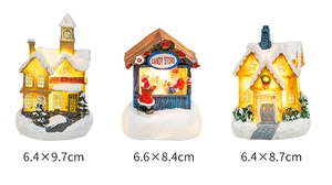 Close-up of lighted Christmas village house ornaments with size details and candy store sign