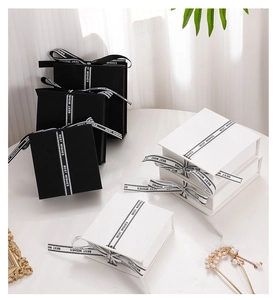 Square black and white jewelry boxes with Best Wishes ribbons and decorative bows