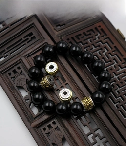 Detailed close-up of rotating Buddhist prayer beads with mantra carvings and black stones