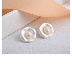 Close-up of baroque freshwater pearl earrings with irregular white wavy frames